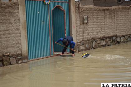 Un niño evita que el agua ingrese a su casa /LA PATRIA