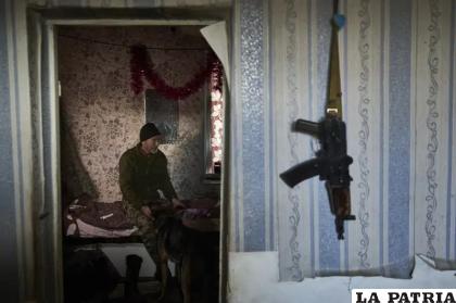 
Un soldado ucraniano descansa acompañado de un perro dentro de una casa cerca de Bakhmut 
/AP Foto/Libkos