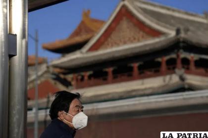 
Una persona con una máscara para protegerse contra el Covid-19 cerca del Templo Lama en Beijing 
/Foto AP/Ng Han Guan