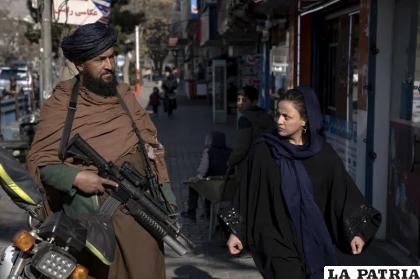 Una mujer pasa al lado de un guardia talibán en Kabul /Foto AP /Ebrahim Noroozi