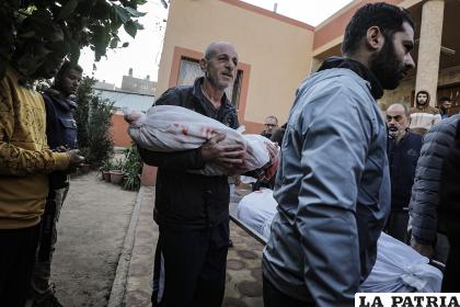 Imagen de archivo de un anciano llevando entre sus brazos el cadaver de un niño muerto por los bombardeos israelíes en Gaza/EFE/EPA/HAITHAM IMAD